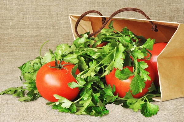 Tomaten en peterselie in een papieren verpakking — Stockfoto