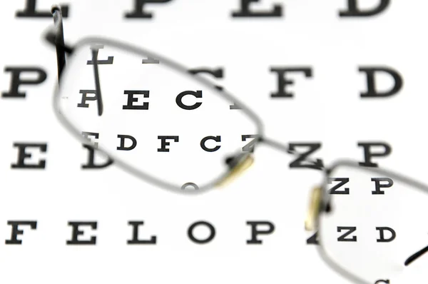 Gafas graduadas y tabla de pruebas oculares —  Fotos de Stock
