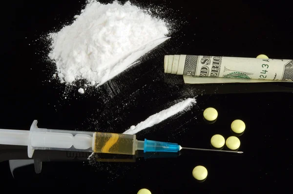 Drogas. Cocaína, dinero, jeringa y tableta . — Foto de Stock