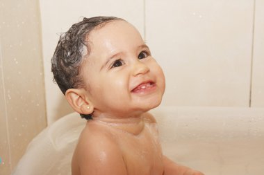 Litlle baby bathes in a bathroom clipart