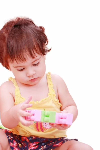 Baby in yellow shirt playing with toys — Stock Photo, Image