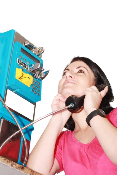 Женщина с удовольствием разговаривает по общественному телефону — стоковое фото