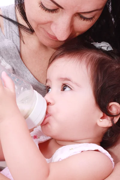 Mother and baby drinking milk from bottle in a white background — Stock Photo, Image