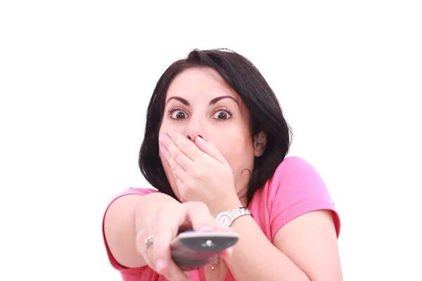 Mujer joven asustada mientras ve la televisión en un fondo blanco Fotos de stock