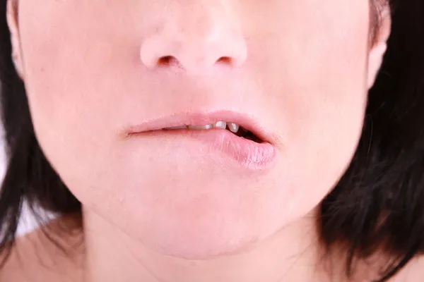 Une femme embarrassée mordant sur sa lèvre — Photo