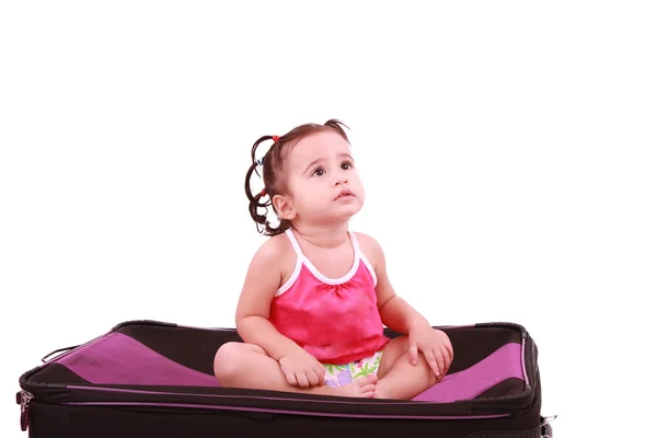 Petite fille mignonne assise sur la valise noire — Photo