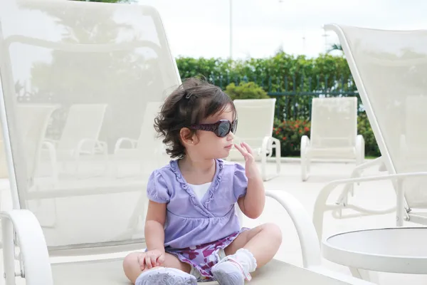 Schattige jonge babymeisje dragen van een zonnebril in flirten positie — Stockfoto