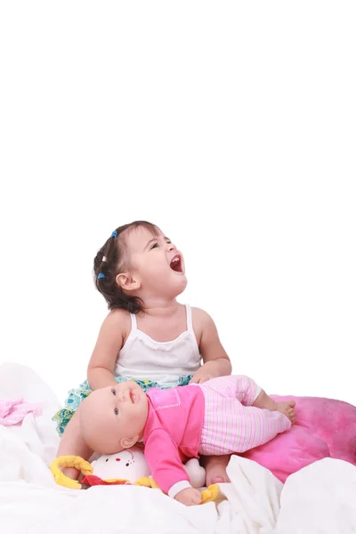 Щаслива маленька дівчинка сидить у ліжку зі своїми ляльками — стокове фото