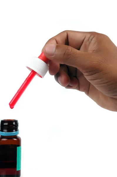 Male hand holding a syrup medicine dropper — Stock Photo, Image