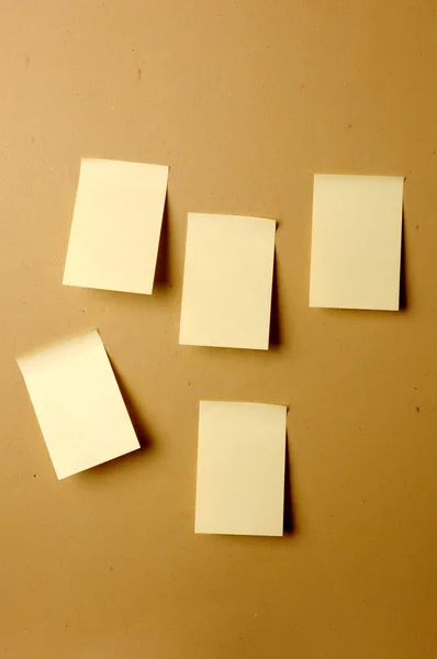 Sheets of paper stuck to the wall brown — Stock Photo, Image