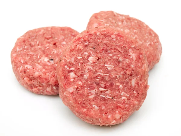 Rå nötkött hamburgare på nära håll på vit — Stockfoto