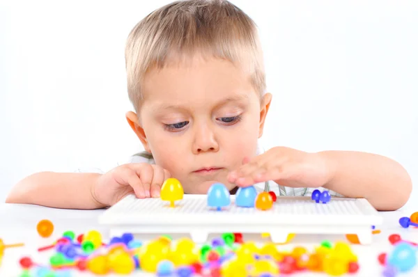 Weinig schattige jongen speelt met veelkleurige mozaïek — Stockfoto