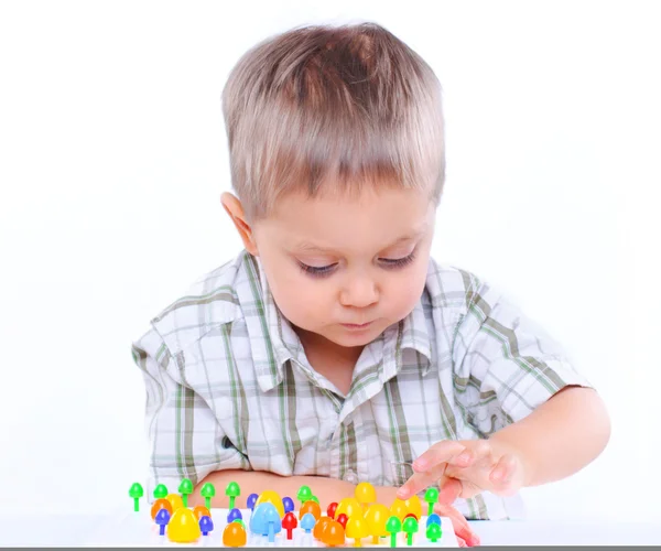 Kleiner süßer Junge spielt mit buntem Mosaik — Stockfoto