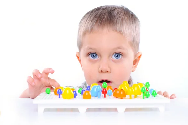 Menino bonito brincando com mosaico multicolorido — Fotografia de Stock