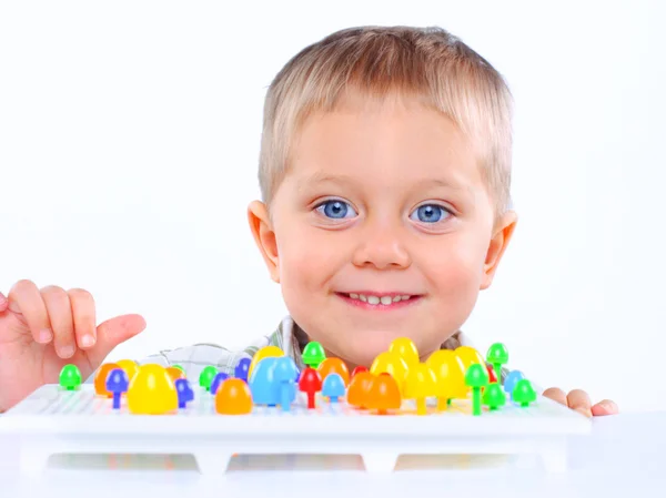 Malý roztomilý chlapec hraje s mnohobarevné mozaiky — Stock fotografie