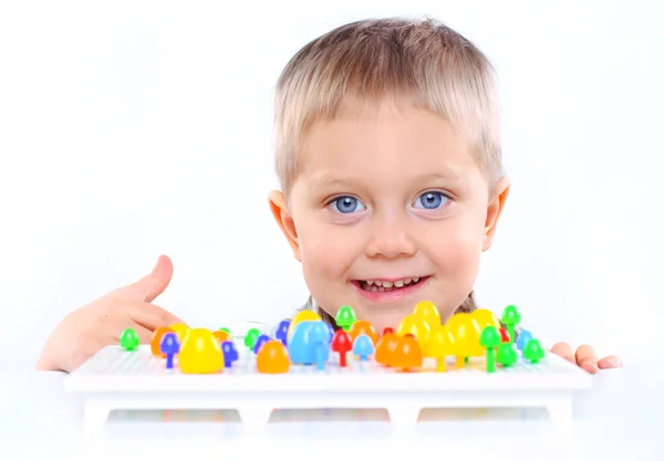 Liten söt pojke leker med flerfärgad mosaik — Stockfoto