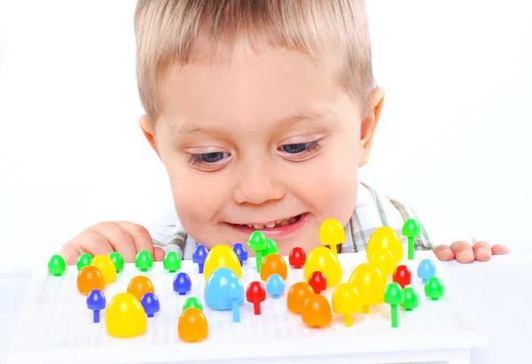 Маленький милий хлопчик грає з різнокольоровою мозаїкою — стокове фото
