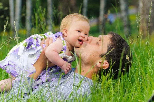 Šťastný otec s dcerou v trávě — Stock fotografie