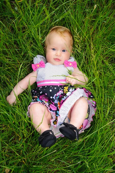 Una bella bambina sdraiata sull'erba — Foto Stock
