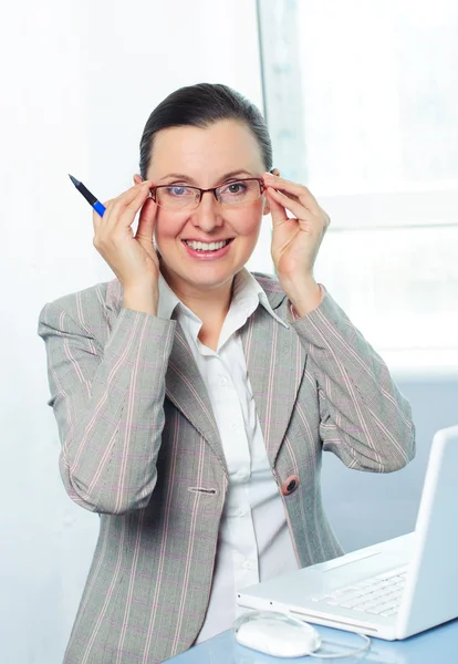 Leende ung affärskvinna med glasögon med laptop — Stockfoto