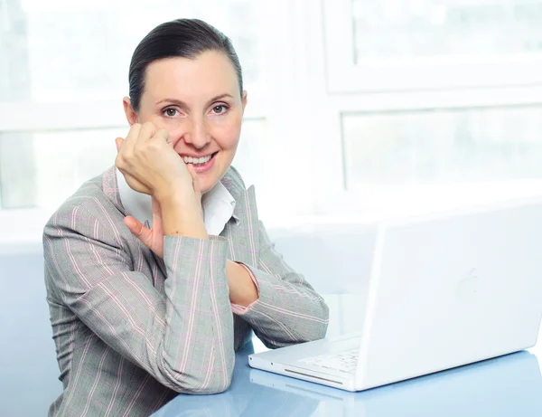 Sorrindo jovem mulher de negócios usando laptop — Fotografia de Stock