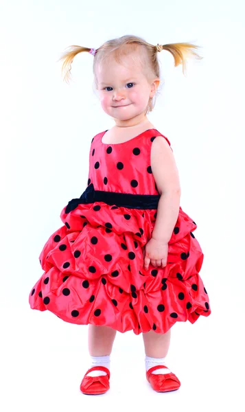 Niedliches kleines Mädchen in einem roten Kleid. im Atelier. isoliert — Stockfoto