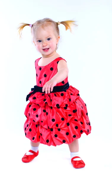Niedliches kleines Mädchen in einem roten Kleid. im Atelier. isoliert — Stockfoto