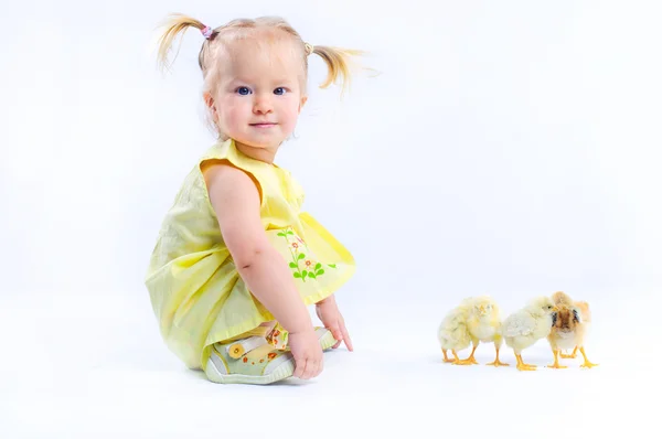 Cute dziewczynka w żółtej sukience z naprawdę żywe kury. — Zdjęcie stockowe