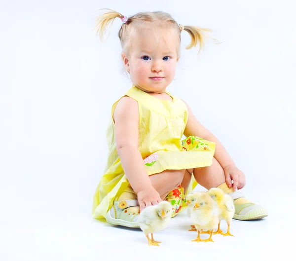 Cute dziewczynka w żółtej sukience z naprawdę żywe kury. — Zdjęcie stockowe