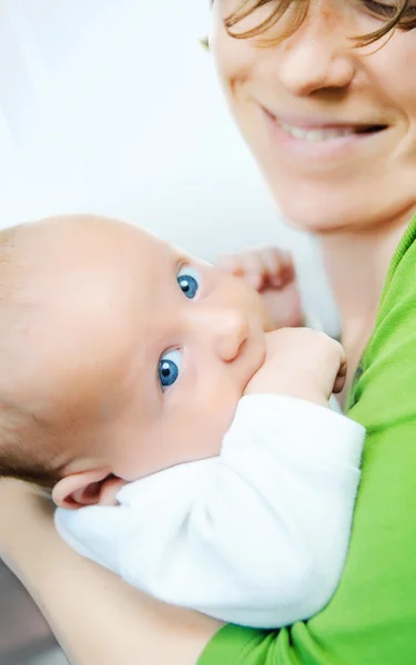 Zadowolony ładny dziecka leżącego na jego ręce matki — Zdjęcie stockowe