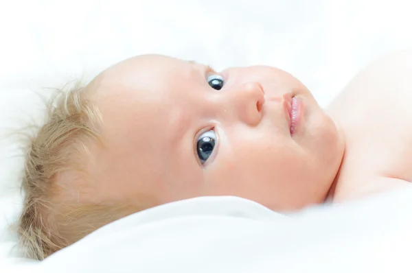 Beautiful baby girl is lying in a bed. — Stock Photo, Image