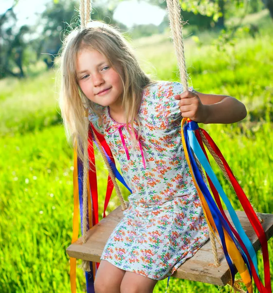 Молодая девушка на качелях — стоковое фото