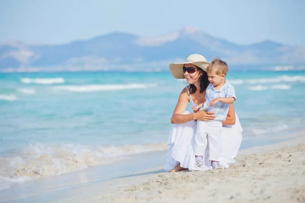 Jovem mãe com seu filho em férias na praia — Fotografia de Stock
