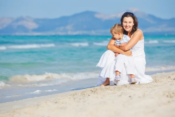 Молодая мать с сыном на пляже — стоковое фото