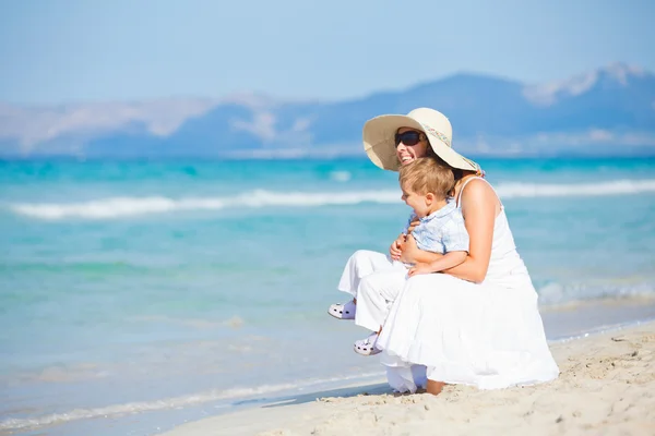 Młoda matka z synem na wakacje na plaży — Zdjęcie stockowe