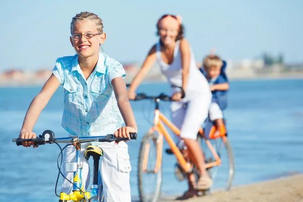 Cute girl with her mother and brother ride bikes — Stock Photo, Image