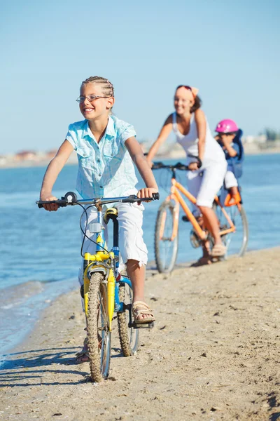 Annesi ve kardeşi ile şirin kız bisiklet sürmek — Stok fotoğraf