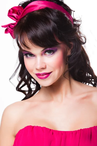 Portret van mooi meisje met donkere haren dragen van roze op witte achtergrond — Stockfoto