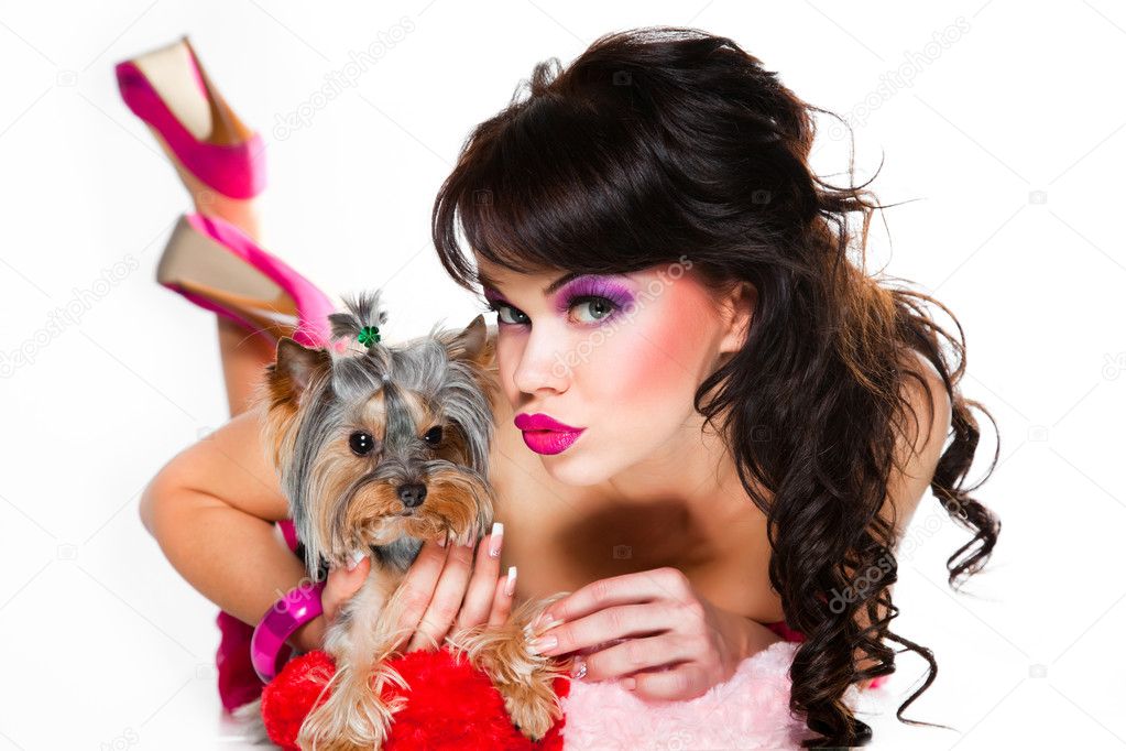 Beautiful girl wearing pink with small dog on white