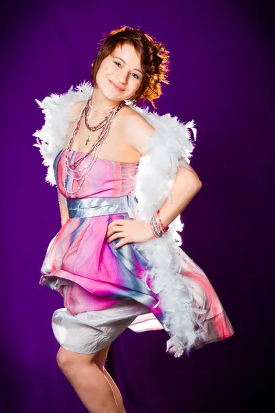 Girl with pink dress and white boa posing on purple — Stock Photo, Image