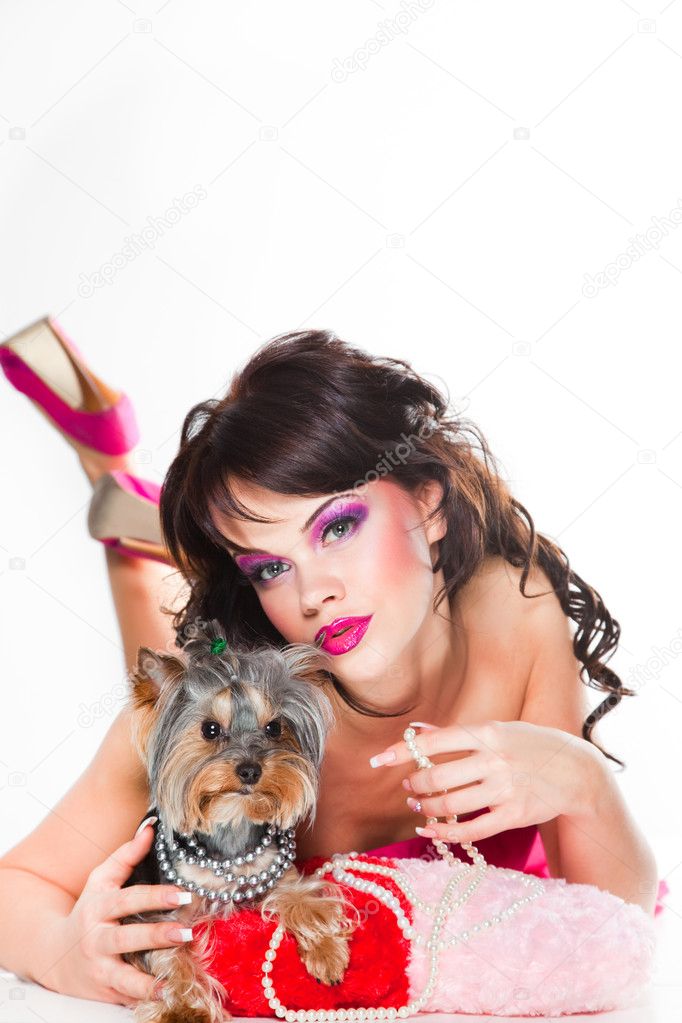 Beautiful girl in pink with small dog on white background