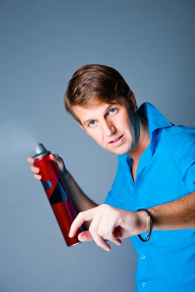 Hairdresser man with hairspray on grey — Stock Photo, Image