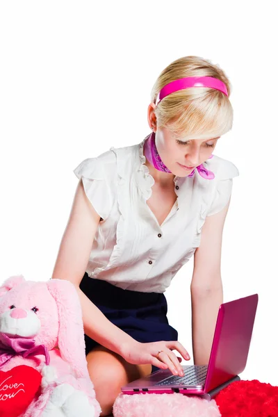 Menina loira bonita trabalhando com laptop rosa em branco isolado — Fotografia de Stock