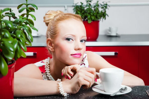 Дівчина з чашкою кави в інтер'єрі кухні — стокове фото