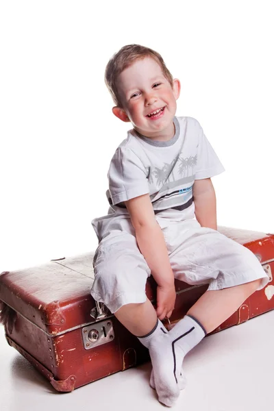Niño encantador con maleta vintage sobre fondo blanco — Foto de Stock