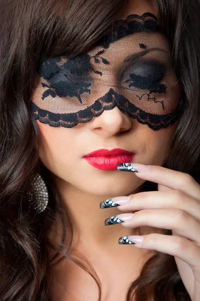 Lockande brunett tjej med lacy mask på hennes ögon — Stockfoto