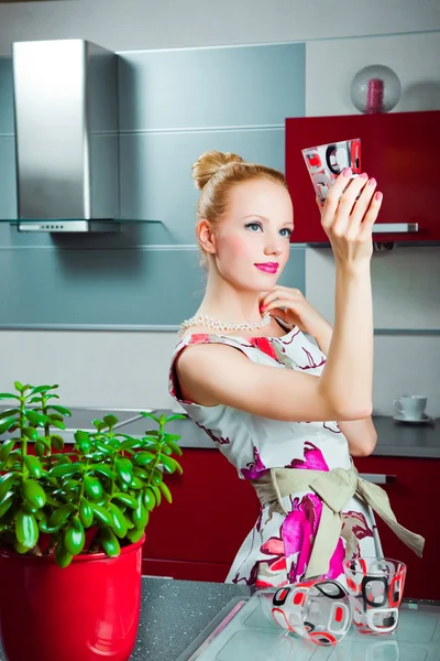 Huisvrouw met schoon glas in interieur van keuken — Stockfoto