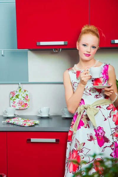 Блондинка з чашкою кави в інтер'єрі кухні — стокове фото