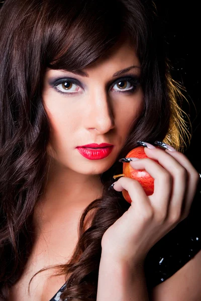 Όμορφη μελαχρινή κοπέλα με μήλο σε μαύρο — Φωτογραφία Αρχείου