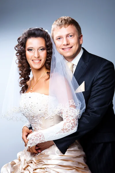 Čerstvě vdaná, ženich a nevěsta na grey — Stock fotografie